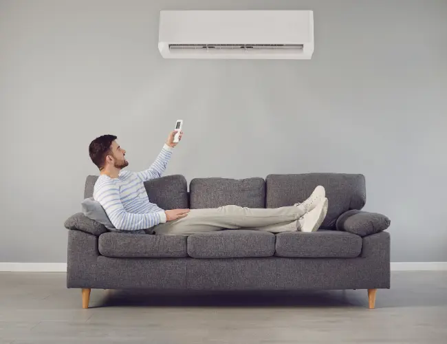 Cliente utilizando aire acondicionado desde el sofá en su vivienda